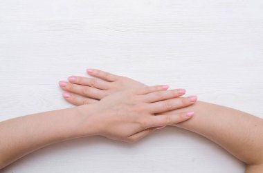 Beyaz ahşap arka plan üzerinde izole kadın eller.