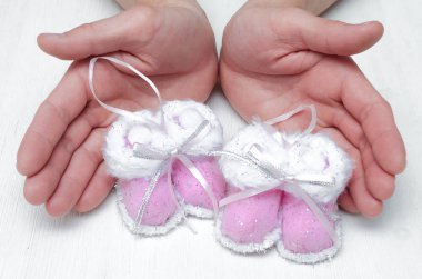 Yeni doğan bebek patik Noel oyuncak babası beyaz arka plan üzerinde eller.