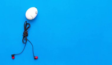 Üzgün tavuk yumurta adam kulaklık beden ile mavi arka plan üzerinde uzaklaşıyor.