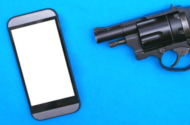 Bir boş ekran ve mavi bir arka plan üzerinde siyah tabanca ile cep telefonu.
