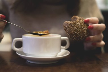 Kadın yemek odasında ekmekle lezzetli bir çorba içiyor..