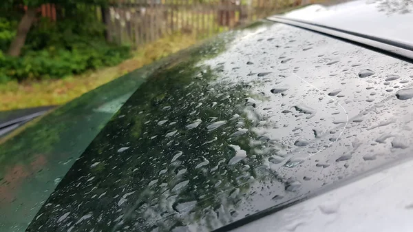 Raindrops on the rear window of the car.