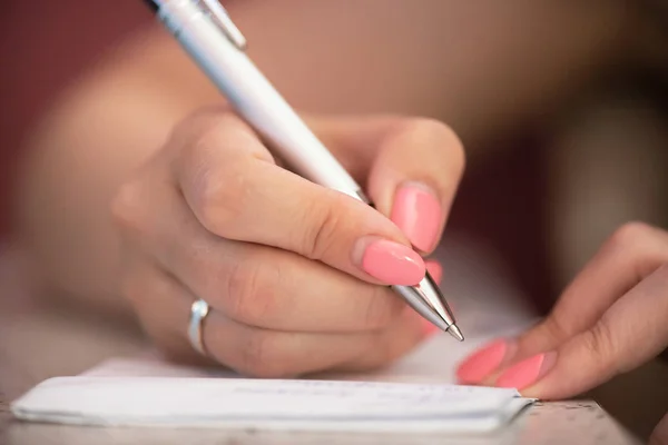 Mujer Está Escribiendo Una Nota Bloc Notas Con Bolígrafo — Foto de Stock