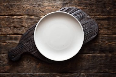 Yaşlı ahşap kicthen kurulu arka plan üzerinde gıda için bir kopya alanı ile yukarıda boş bir plaka ile eski kesme tahtası.