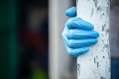 Tıbbi koruyucu eldiven giymiş bir kadın bir evin penceresini açar..