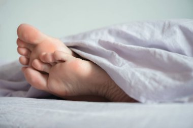 Battaniyenin altındaki kadın ayakları. Yaklaş..