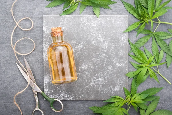 Cannabis Cbd Butelka Olejku Eterycznego Zielone Liście Szarym Płaskim Tle — Zdjęcie stockowe