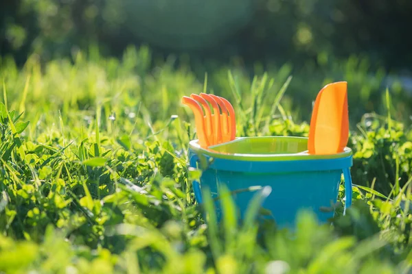 Bayi Mainan Ember Dengan Menyapu Dan Sekop Latar Belakang Rumput — Stok Foto