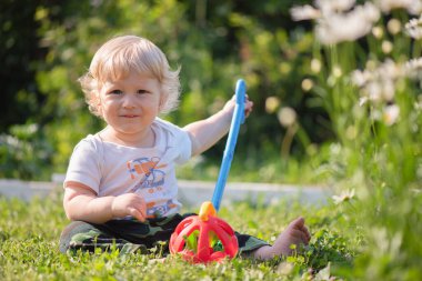 Bebek dışarıda oyuncaklarla oynuyor..