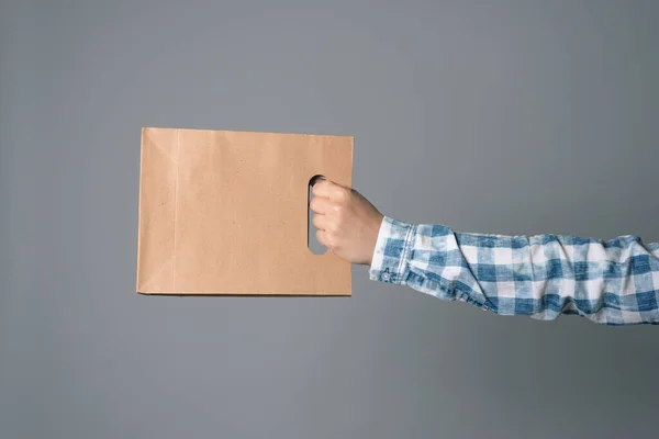 Una Bolsa Papel Mano Masculina Aislada Sobre Fondo Gris — Foto de Stock