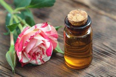 Gül çiçeği yağı masanın üzerinde küçük bir şişede.