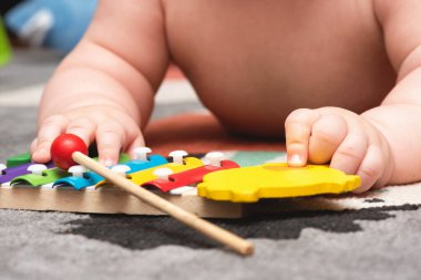 Küçük çocuk yerde çocuklar için müzik aleti çalıyor..