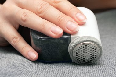 Kadın, makara temizleyicisiyle giysileri temizliyor. Kapatın..