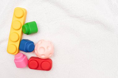 Beyaz havluyla arka planda çocuk oyuncakları.