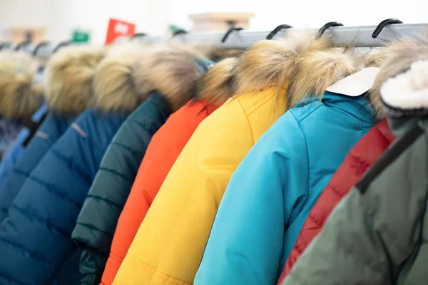 New winter jackets on a store counter abstract background.