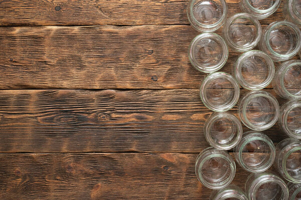 Empty glass jars from baby food on the wooden table flat lay background.