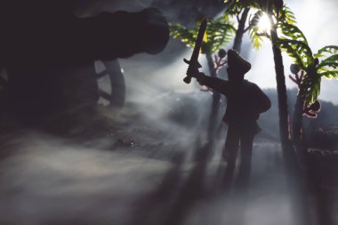 Gece sisinde kılıcını kaldıran şapkalı korsan kaptan..