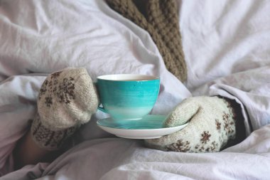 Eldivenli hasta kadın limonlu sıcak çayla ısınıyor..