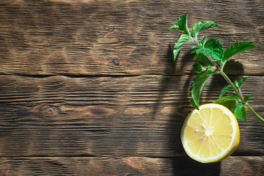 Tahta bir arka planda limon ve nane yaprağı.