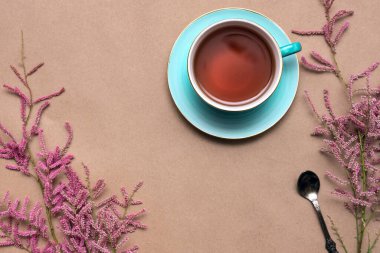 Bir fincan sıcak çay ve kahverengi arka planda tamarix gallica ağacı dalları..