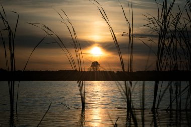 Gölün arka planında gün batımı.