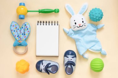 Oyuncak bebekler ve boş bir defter. Yeni doğan bahşişleri. Çocuk oyun listesi.