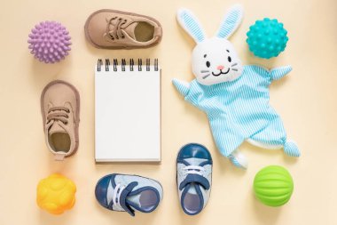 Oyuncak bebekler ve boş bir defter. Yeni doğan bahşişleri. Çocuk oyun listesi.