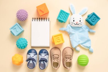 Oyuncak bebekler ve boş bir defter. Yeni doğan bahşişleri. Çocuk oyun listesi.