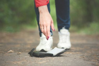 Kadın yerde bir cüzdan bulur ve onu alır..