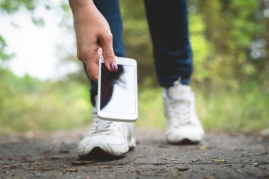 Yerde kaybolmuş bir cep telefonu ve onu bulan bir kişi..