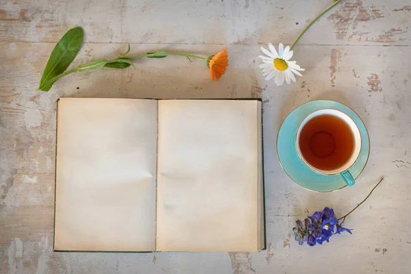 テーブルの上にコピースペース 花やお茶のカップを持つ空白のページオープンブック — ストック写真