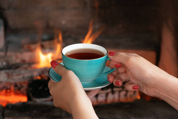 Cup of hot tea and a tamarix gallica tree branches on a brown background.