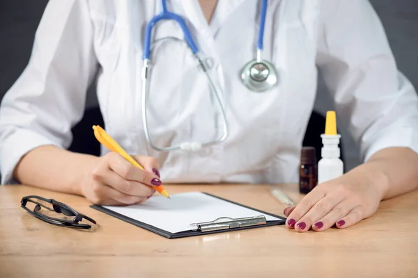 Doktor, tıbbi geçmişini boş bir kağıda kaydediyor. Tıbbi reçete.