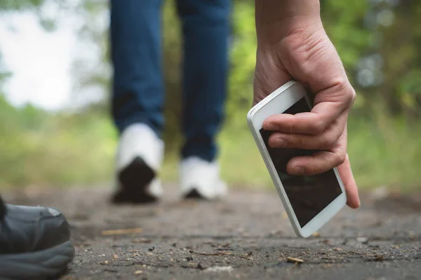 Yerde kaybolmuş bir cep telefonu ve onu bulan bir kişi..