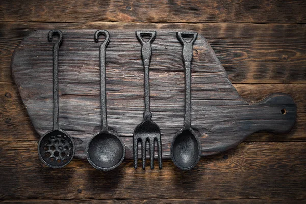 Küchentisch Abstrakter Hintergrund Eisengabel Und Löffel Auf Einem Schneidebrett — Stockfoto