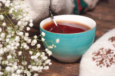 Sıcak kazaklı ve eldivenli kadın sıcak bir çay içiyor..