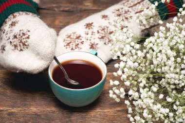 Sıcak kazaklı ve eldivenli kadın sıcak bir çay içiyor..