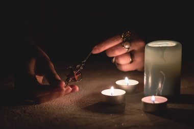 Falcı elinde sihirli bir sarkacı tutuyor..