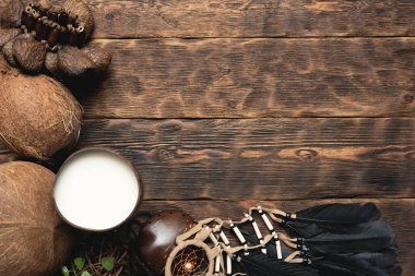 Fincanda hindistan cevizi sütü ve kahverengi tahta masa arkasında hindistan cevizi..