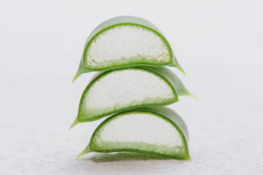 Aloe vera dilimlenmiş yapraklar beyaz arkaplanda izole edilmiş.