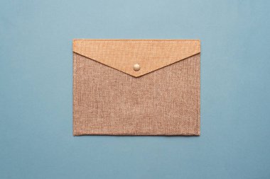 Mavi düz arkaplanda kahverengi posta zarfı.