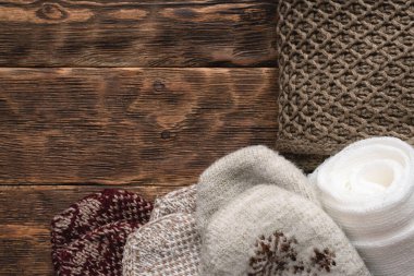 Kahverengi ahşap masa arkasında kışlık kalın giysiler.