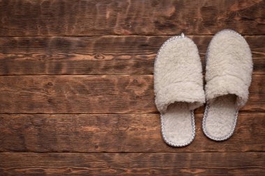 Koridorun arka planındaki ahşap zeminde yün terlikler..