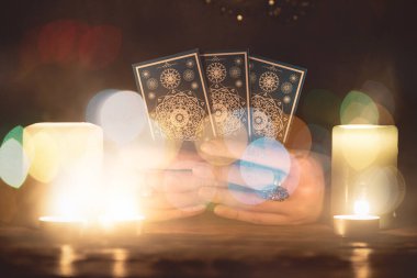 Elinde tarot kartları olan falcı yakın çekim yapıyor. Gelecek okuma konsepti.