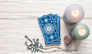 Beyaz ahşap masa arkasında mavi tarot kartları.