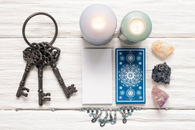 Mavi tarot kartları ve beyaz ahşap masa arka planındaki kaderin anahtarı. Kader kavramına ipucu.