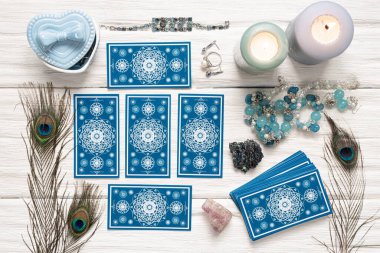 Beyaz ahşap masa arkasında mavi tarot kartları.