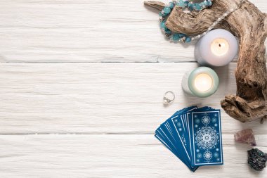 Beyaz ahşap masa arkasında mavi tarot kartları.