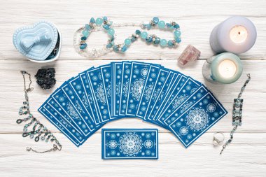 Beyaz ahşap masa arkasında mavi tarot kartları.