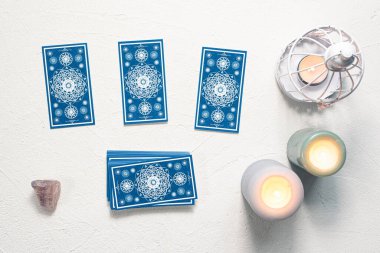 Beyaz taş masa zemininde mavi tarot kartları.